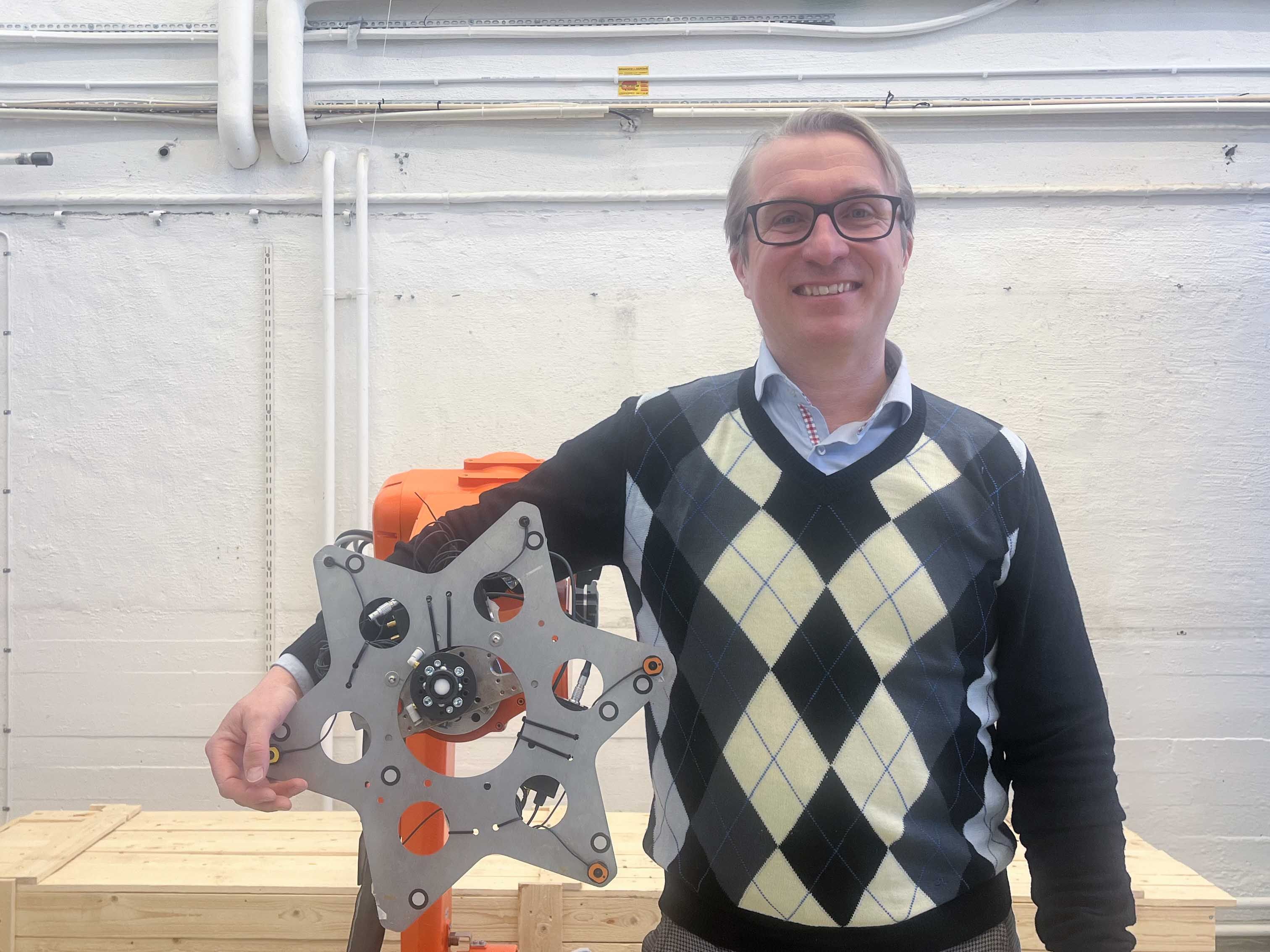 Fredrik Malmgren, CEO of Cognibotics beside a robotic device (Cognical) in a workshop.